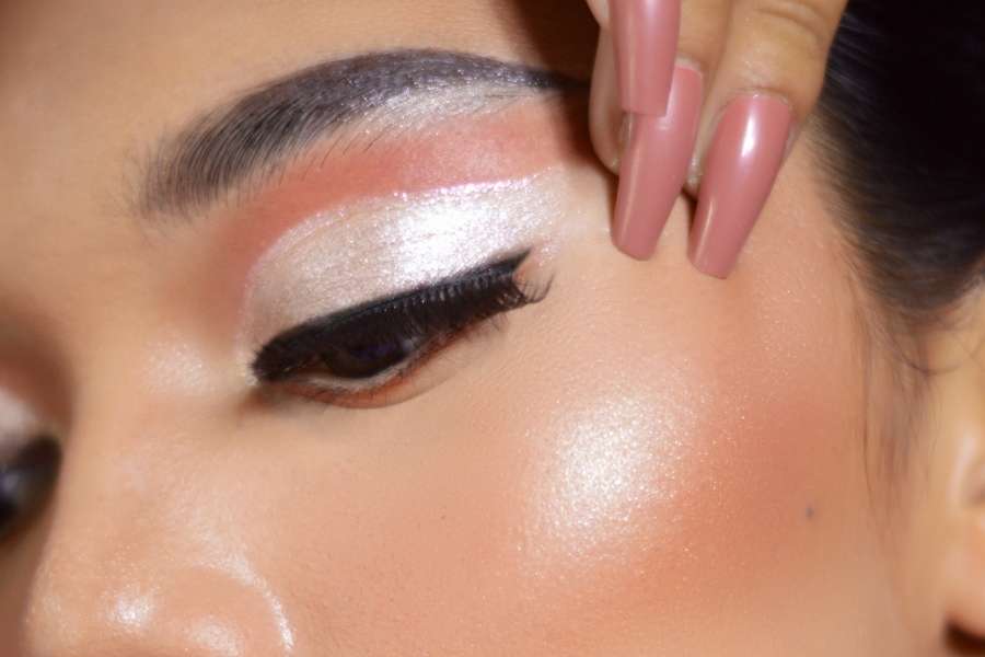 Gros plan sur un maquillage des yeux fort aux reflets irisés et nacrés.